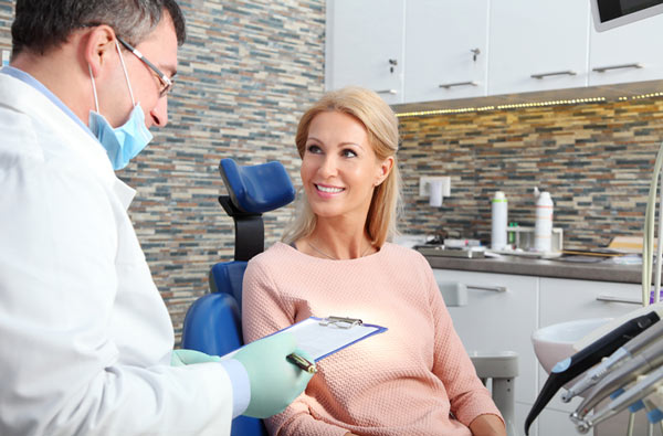 Woman talking to dentist during dental exam at Radiance Dental in West Chester, PA